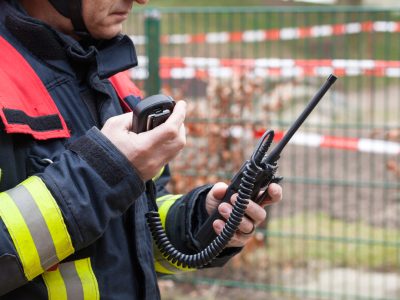 Firefighter holding a walkie-talkie during an emergency response