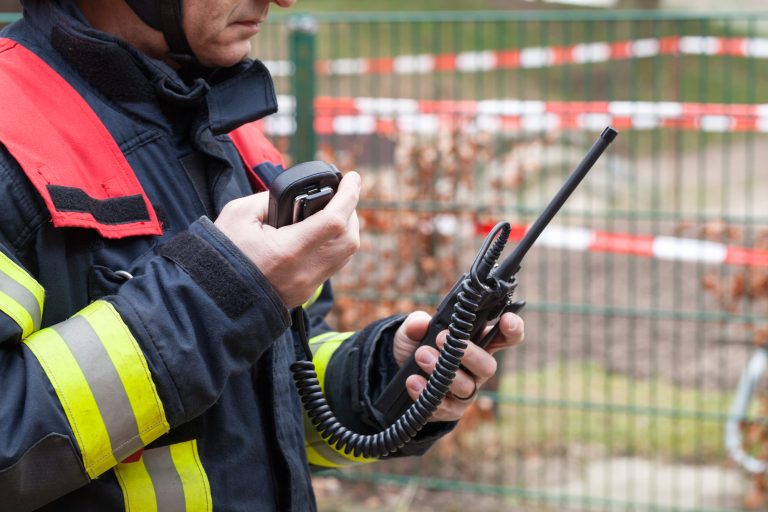 Firefighter holding a walkie-talkie during an emergency response